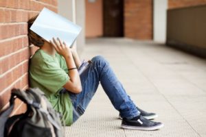 photo of boy with binder covering his face