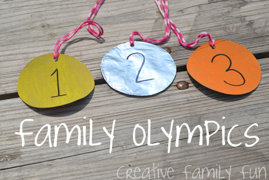 photo image of three paper medals - gold, silver, bronze - on ribbons, laying on wood deck