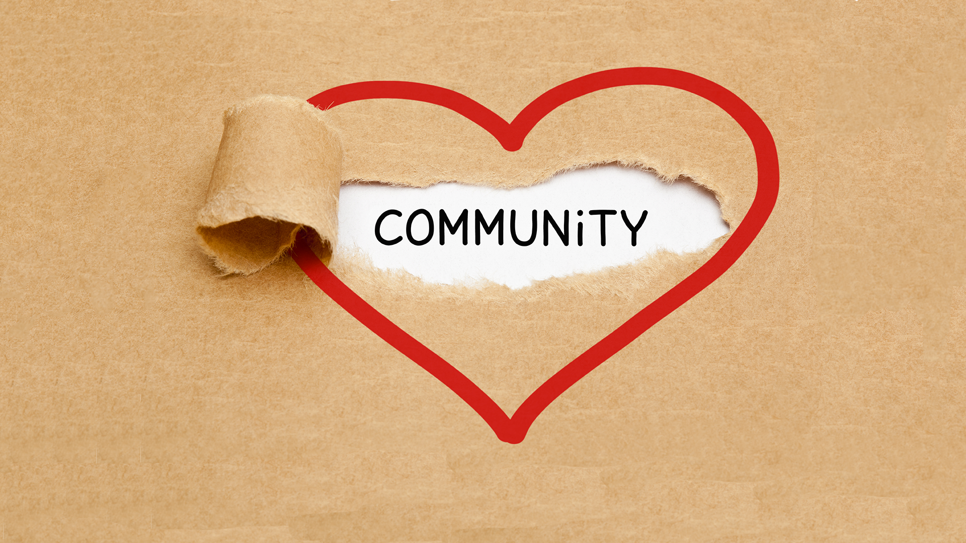 image of red heart outline on brown paper, paper ripped in center section, peeled back to reveal the word community